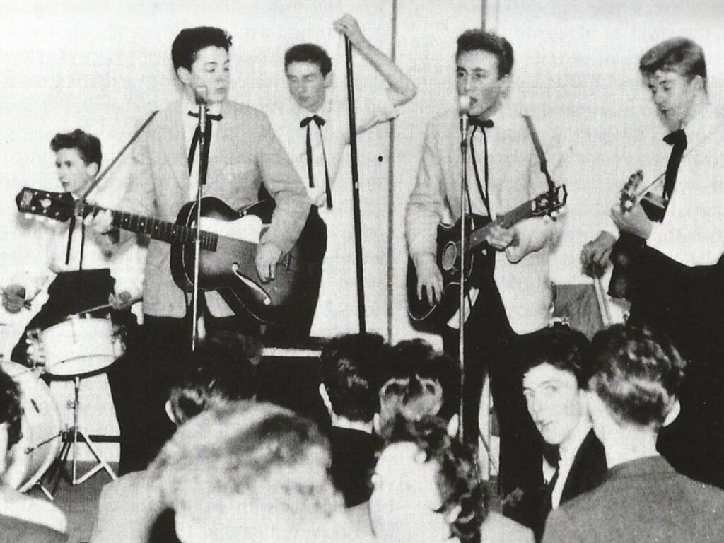How old were The Beatles when they scored their first number one?